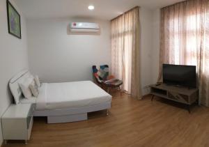 ein Wohnzimmer mit Couch und Fernseher in der Unterkunft Coconut Bay Lodge in Bandar Seri Begawan