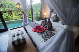 uma cama num quarto com uma grande janela em Rumah mini em Ubud