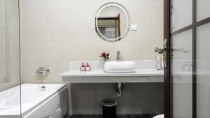 a white bathroom with a sink and a mirror at Green Rose Hotel in Batam Center +10 photos