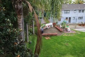 an aerial view of a backyard with a bench and palm trees at Dolphin Motel in Paihia