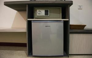 a small refrigerator with a microwave on top of it at Green Rose Hotel in Batam Center