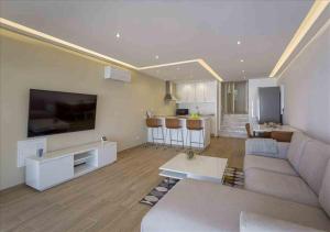 a living room with a couch and a large tv at Vicky Rae Beach House - Vale do Lobo in Almancil