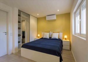 ein Schlafzimmer mit einem großen Bett mit einer blauen Decke in der Unterkunft Vicky Rae Beach House - Vale do Lobo in Almancil + 8 Fotos