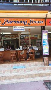 a man sitting in front of a hamory house at Harmony House-SHA Plus in Phi Phi Islands