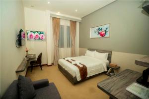 a hotel room with a bed and a desk at Green Rose Hotel in Batam Center
