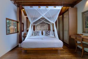 a bedroom with a bed with a canopy at Tandjung Sari Hotel in Sanur
