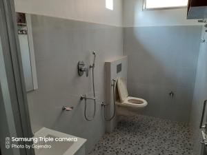 a bathroom with a toilet and a shower at Haobam House in Imphal