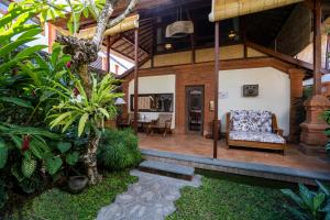 una casa con portico, divano e sedia di Tandjung Sari Hotel a Sanur