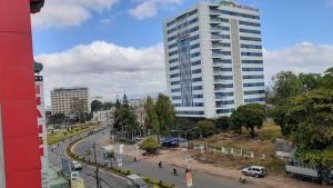 una calle de la ciudad con un edificio blanco alto en Nhà nghỉ Bình Yên en Pleiku