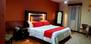 瓜納華托的住宿－穆里略廣場酒店，一间卧室配有一张带红色枕头的大床