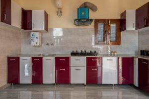 a kitchen with red and white cabinets in a room at StayVista at Lake Trails with Lawn, Balcony & Lake View in Nainital