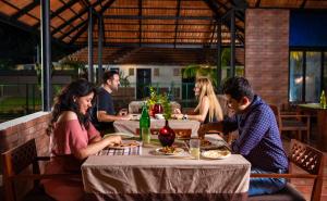 grupa ludzi siedzących przy stole w restauracji w obiekcie Alleppey Haven Beach Villa w mieście Alappuzha