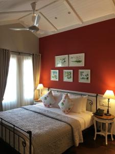 a bedroom with red walls and a bed with pillows at BICH DAO Boutique - Dalat in Da Lat