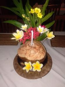 a candle in a vase with flowers on a table at Barclona Guesthouses Lovina in Buleleng