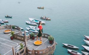 a woman standing on a dock with boats in the water at BrijRama Palace, Varanasi - By the Ganges in Varanasi