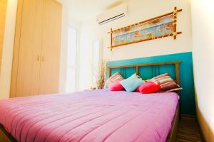 um quarto com uma grande cama rosa com almofadas coloridas em Big 2 Bedroom, XXL Pool, in Hearth of Ayia Napa em Agia Napa