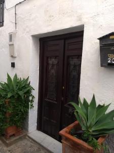 a black door on a white building with plants at Casa Libertad in Órgiva