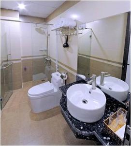 ニンビンにあるVan Giang Hotelのバスルーム(白いトイレ、シンク付)