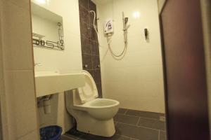 a bathroom with a toilet and a sink and a phone at HOTEL PREMIUM in Ipoh