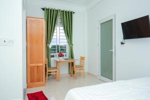 a bedroom with a bed and a table and a window at Vân Mây Homestay Hội An in Hoi An