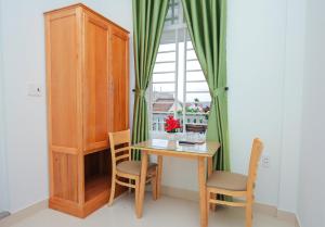 een kamer met een tafel en stoelen en een raam bij Vân Mây Homestay Hội An in Hội An