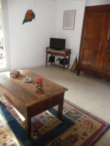 a living room with a wooden coffee table and a desk at Gîte "Chante' Relle" in Privas