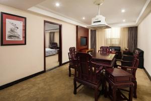 a room with a dining table and a living room at Gorgeous Hotel in Guangzhou