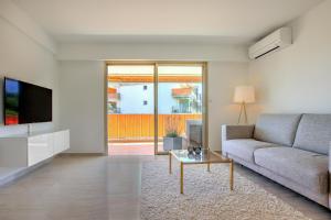 uma sala de estar com um sofá e uma televisão em Modern Family Home 5 min to Beach +Pool +Garage em Antibes