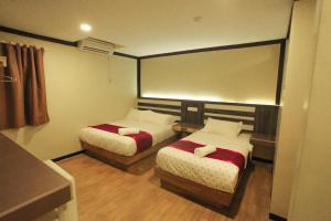 a hotel room with two beds and a mirror at HOTEL PREMIUM in Ipoh
