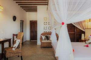 sypialnia z łóżkiem z zasłoną ślubną w obiekcie Zanzibar Magic Boutique Hotel w mieście Matemwe