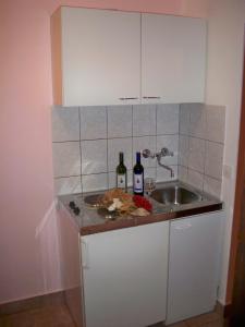 una cocina con fregadero y 2 botellas de vino en Guesthouse Lučić, en Orebić
