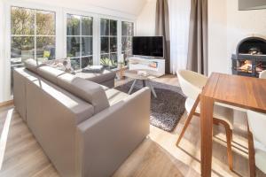 a living room with a couch and a table at Winkelschiffchen II mit Sauna in Juist