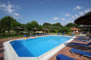 una grande piscina con sedie blu e ombrelloni di Villagio a Città di Lefkada