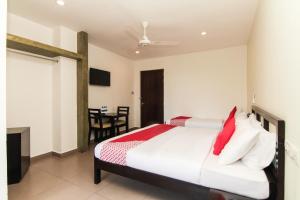 Saninro Hotel - Ragama في Ragama: غرفة نوم بسرير كبير وطاولة