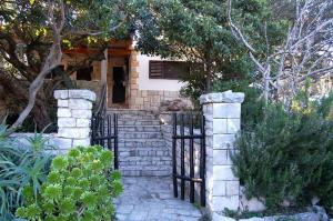 a house with a gate in front of a house at Vacation House Planika in Vela Luka