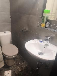 ein Badezimmer mit einem weißen WC und einem Waschbecken in der Unterkunft YourHostel Club in Kiew