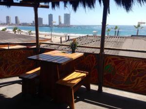 a table and benches on a beach with the ocean at Backpacker's Hostel Iquique in Iquique