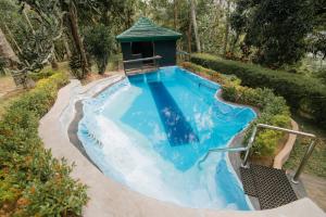 a swimming pool in a garden with a gazebo at Man Mountain Villa in Matale