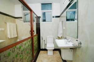 a bathroom with a white toilet and a sink at Grand Rovinka Hotel in Dehiwala +34 photos