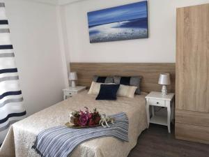 a bedroom with a bed with a tray of flowers on it at Beachfront modern and spacious apartment in Torrevieja