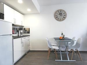 a kitchen with a table and a clock on the wall at Beachfront modern and spacious apartment in Torrevieja +21 photos