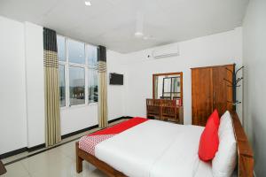 Grand Rovinka Hotel في دهيفالا: غرفة نوم بسرير كبير ومخدات حمراء