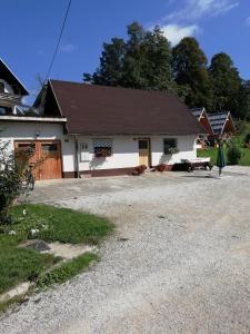 a white house with a black roof and a driveway at Apartma Pr' Vok in Lesce