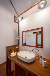 La salle de bains est pourvue d'un lavabo blanc et d'un miroir. dans l'établissement Kingfisher Ecolodge, à Ban Kian-Ngông