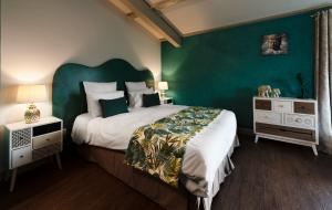 a bedroom with a large bed and a green wall at Le Cèdre de Soyons in Soyons