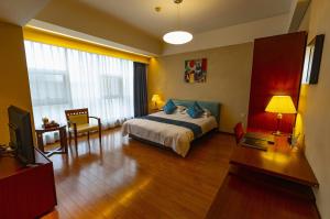 a bedroom with a bed and a desk and a television at East King Business Hotel (West Lake store, Hangzhou) in Hangzhou
