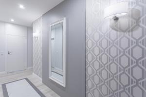 corridoio con specchio e parete bianca di Lion Apartments - NaviFlat Brabank Premium Apartment with parking a Danzica