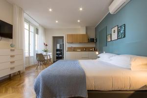 1 dormitorio con 1 cama grande y pared azul en Aqualago casa vacanze - apartament B, en Verbania