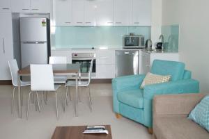 Itara Apartments في تاونزفيل: غرفة معيشة مع أريكة زرقاء وطاولة