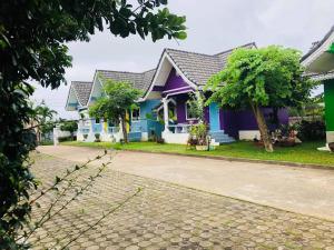 a row of houses with blue and purple paint at Baan Chom Chan Resort in Sattahip